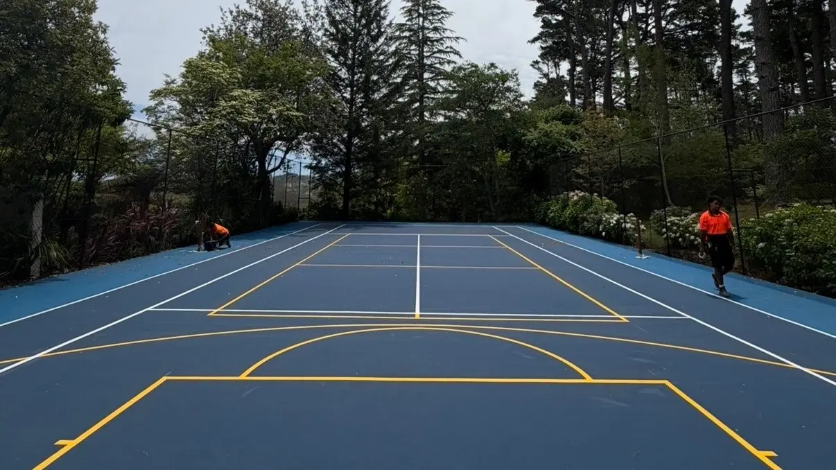 Backyard multi-sport conversion, Sydney: two-tone blue acrylic with a basketball key and pickleball kitchen lines on one slab — Speedy Resurfacing.