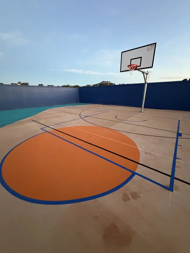 Tan court at dusk — Basketball court resurfacing by Speedy Resurfacing