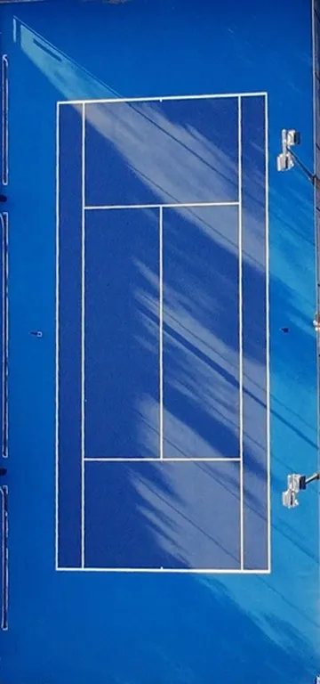 Single tennis court from above with fresh royal blue acrylic and crisp white line marking