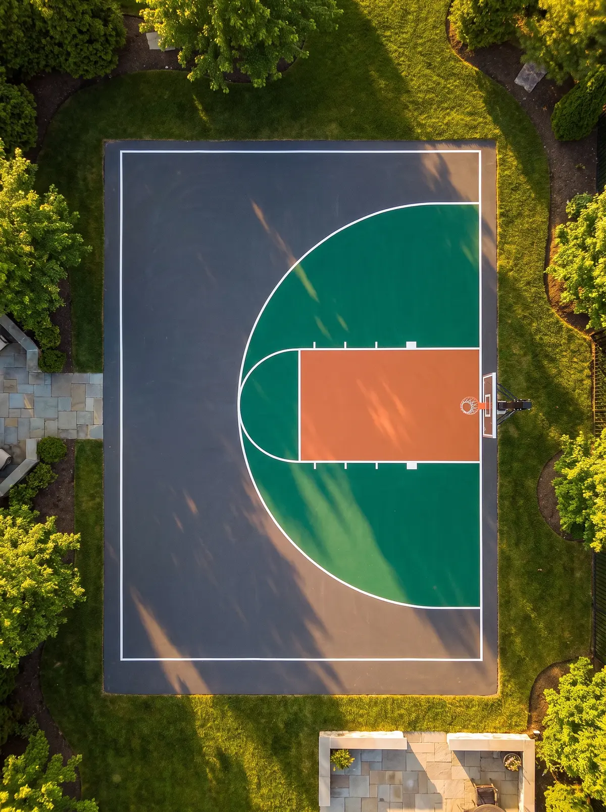 Aerial view of a High-Energy Arena residential court — charcoal surface with emerald and terracotta feature zones