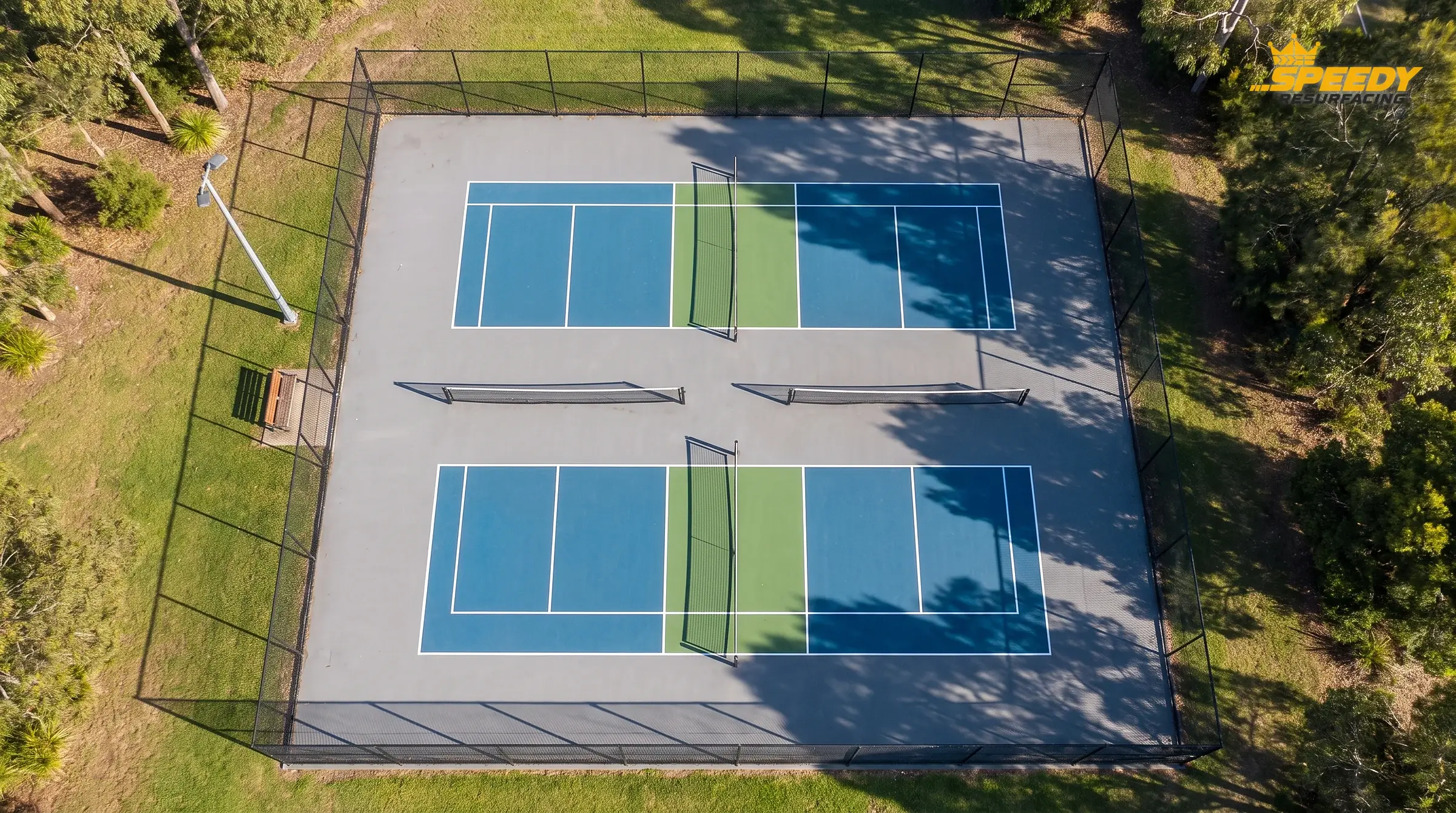 Lines versus footprint: two 20 × 44 ft courts inside their 30 × 60 ft envelopes, with the light pole and bench kept outside the run-off apron.