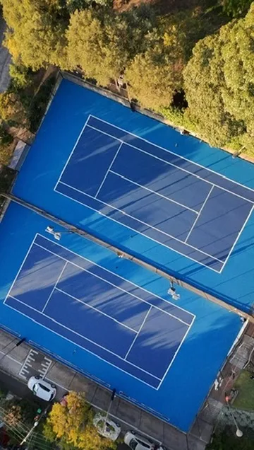 Aerial view of two newly completed royal blue tennis courts in Sydney