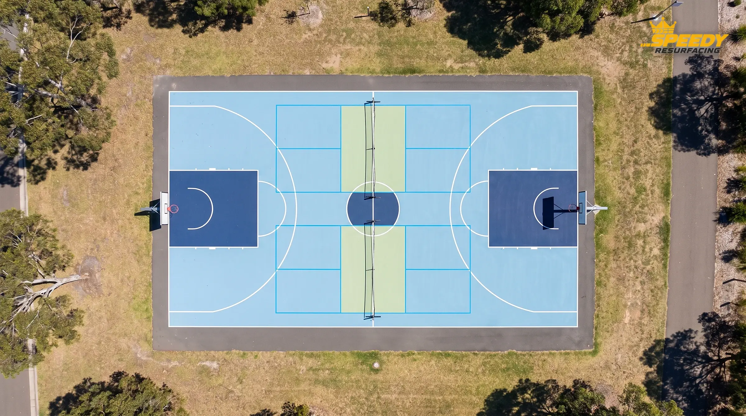 Offset key zones from above: two pickleball courts placed crosswise so their kitchens sit clear of the basketball free-throw keys — no overlapping feature zones.